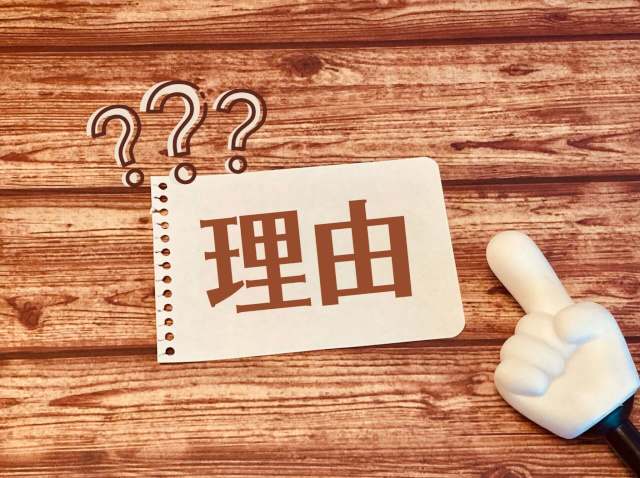 理由と書かれた紙をさす指し棒
